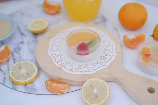 Fruit jelly with orange juice, lemon and kiwi on the table