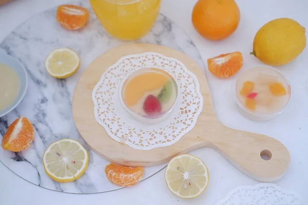 Fruit jelly with orange juice, lemon and kiwi on the table