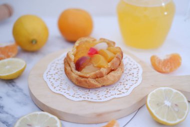 Taze meyveli ev yapımı limonlu tart ve beyaz arka planda portakal suyu.