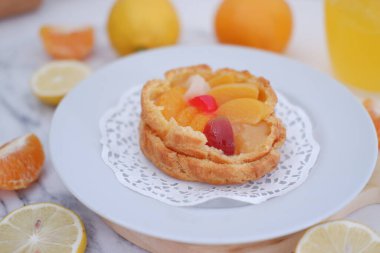 Bardakta taze portakal suyu ve beyaz arka planda taze narenciye meyvesi..