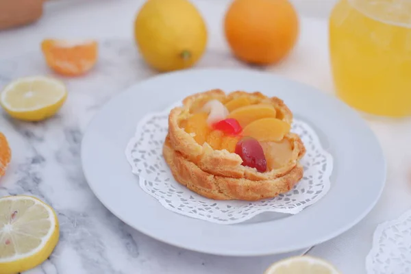 Fruchtkuchen Auf Weißem Teller Mit Zitronen Und Mandarinen — Stockfoto