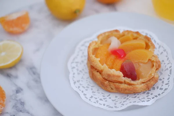 Fruchtkuchen Auf Weißem Teller Mit Zitronen Und Mandarinen — Stockfoto