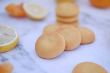 Limon, portakal ve limon dilimleri beyaz mermer bir masada..