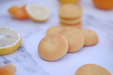 Limon, portakal ve limon dilimleri beyaz mermer bir masada..