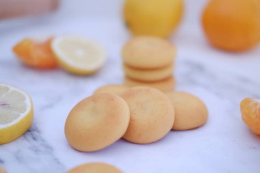 Limon, portakal ve limon dilimleri beyaz mermer bir masada..