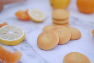 Limon, portakal ve limon dilimleri beyaz mermer bir masada..