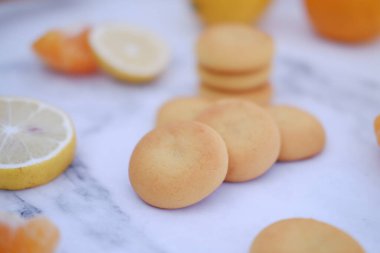 Limon, portakal ve limon dilimleri beyaz mermer bir masada..