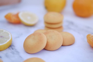 Limon, portakal ve limon dilimleri beyaz mermer bir masada..