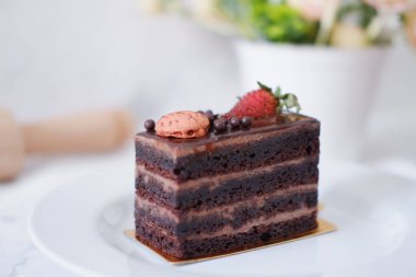 Çilekli çikolatalı kek ve beyaz tabakta badem kurabiyesi.