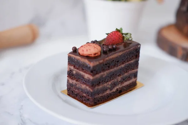 Piece Chocolate Cake Strawberries Macaroons White Plate — Stock Photo, Image