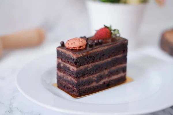白盘上夹着草莓和金银花的一块巧克力蛋糕 — 图库照片