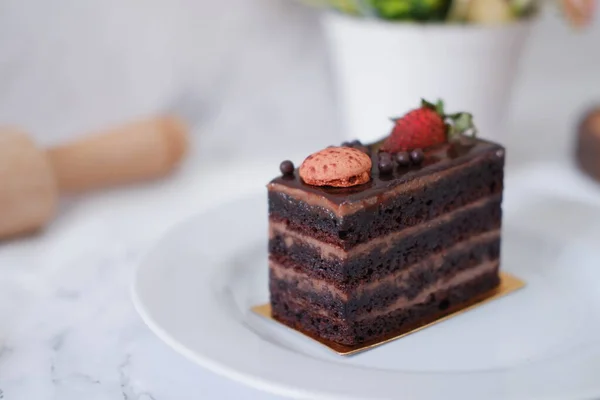 白盘上夹着草莓和金银花的一块巧克力蛋糕 — 图库照片