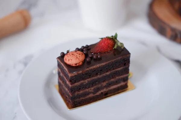 Piece Chocolate Cake Strawberries Macaroons White Plate — Stock Photo, Image