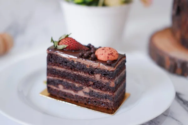 Stück Schokoladenkuchen Mit Erdbeeren Und Makronen Auf Weißem Teller — Stockfoto