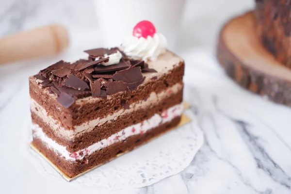 白い大理石の背景にホイップクリームとチェリーとチョコレートケーキ — ストック写真