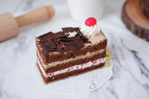 白大理石背景的带有奶油和樱桃的巧克力蛋糕 — 图库照片