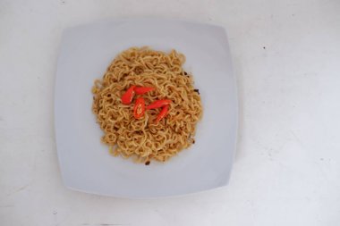 Beyaz arka planda kırmızı biberli şehriye..