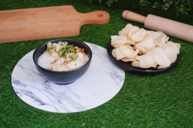 Pilav lapası, yeşil çimenli beyaz tabakta tavuk.