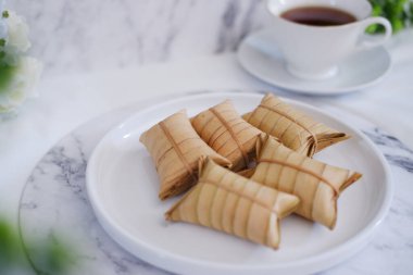 Lepet or Leupeut is a type of snack made from glutinous rice mixed with peanuts, cooked in coconut milk, then wrapped in coconut leaves. Close up view