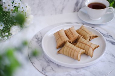 Lepet ya da Löpeut, yer fıstığıyla karıştırılmış, hindistan cevizi sütüyle pişirilmiş ve hindistan cevizi yapraklarına sarılmış bir aperatif türüdür. Görüntüyü kapat