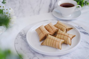 Lepet ya da Löpeut, yer fıstığıyla karıştırılmış, hindistan cevizi sütüyle pişirilmiş ve hindistan cevizi yapraklarına sarılmış bir aperatif türüdür. Görüntüyü kapat