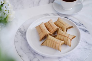 Lepet ya da Löpeut, yer fıstığıyla karıştırılmış, hindistan cevizi sütüyle pişirilmiş ve hindistan cevizi yapraklarına sarılmış bir aperatif türüdür. Görüntüyü kapat