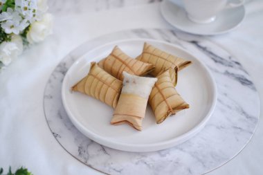 Lepet or Leupeut is a type of snack made from glutinous rice mixed with peanuts, cooked in coconut milk, then wrapped in coconut leaves. Close up view