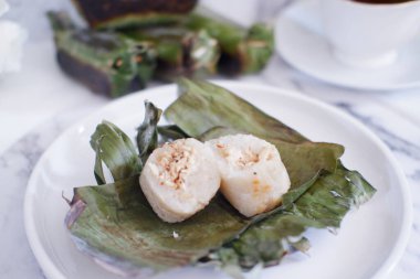 Lemper Bakar. Lemper, glutinous pirinçten yapılmış ve tavuk etiyle doldurulmuş ve muz yapraklarına sarılmış geleneksel bir Endonezya aperatifi. Seçici odak