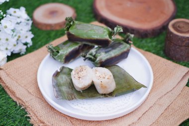 Lemper Bakar. Lemper, glutinous pirinçten yapılmış ve tavuk etiyle doldurulmuş ve muz yapraklarına sarılmış geleneksel bir Endonezya aperatifi. Seçici odak