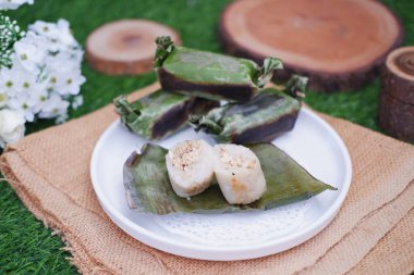 Lemper Bakar. Lemper, glutinous pirinçten yapılmış ve tavuk etiyle doldurulmuş ve muz yapraklarına sarılmış geleneksel bir Endonezya aperatifi. Seçici odak