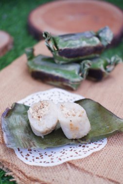 Lemper Bakar. Lemper, glutinous pirinçten yapılmış ve tavuk etiyle doldurulmuş ve muz yapraklarına sarılmış geleneksel bir Endonezya aperatifi. Seçici odak