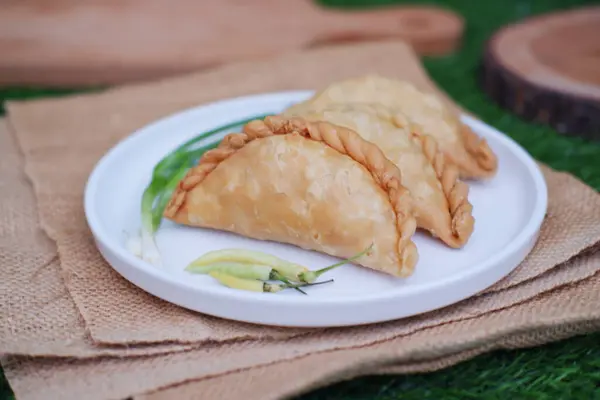 Curry puff or Pastel Goreng is Pastry Popular in Indonesia. fried pastry with filling of sauted vegetable, chicken and boiled egg. accompanied with  sauce or raw chilli pepper