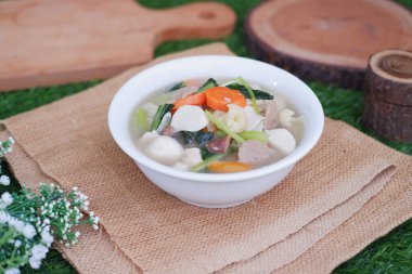 Capcay, kızarmış sebzeleri mantar, köfte ve tavukla karıştır. Beyaz kasede servis edilir.