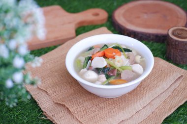 Capcay, kızarmış sebzeleri mantar, köfte ve tavukla karıştır. Beyaz kasede servis edilir.