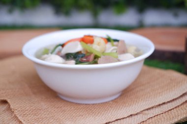 Capcay, kızarmış sebzeleri mantar, köfte ve tavukla karıştır. Beyaz kasede servis edilir.