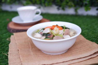 Capcay, kızarmış sebzeleri mantar, köfte ve tavukla karıştır. Beyaz kasede servis edilir.