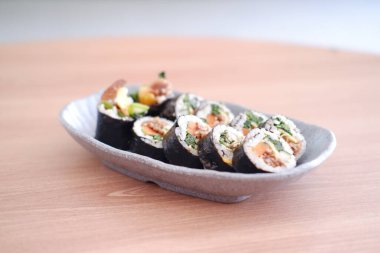 Suşi Japon yemeği tarzında ahşap masa arkasında yuvarlanıyor..