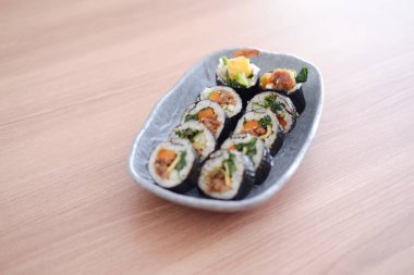 Suşi Japon yemeği tarzında ahşap masa arkasında yuvarlanıyor..