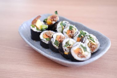 Suşi Japon yemeği tarzında ahşap masa arkasında yuvarlanıyor..