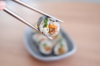 Suşi Japon yemeği tarzında ahşap masa arkasında yuvarlanıyor..