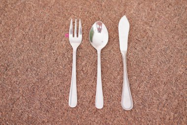 Kumun arka planında kaşık, çatal ve bıçak.