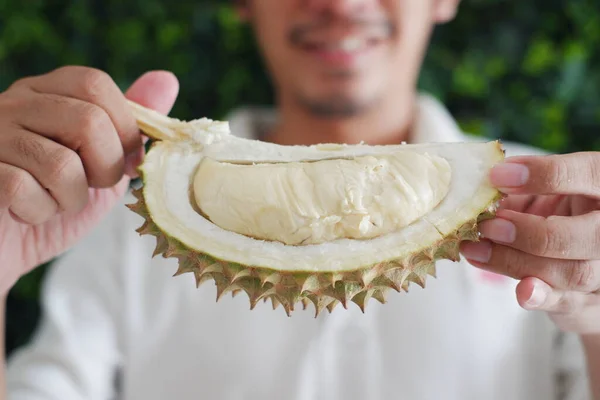 Elinde Durian meyvesi tutan genç adama yaklaş..