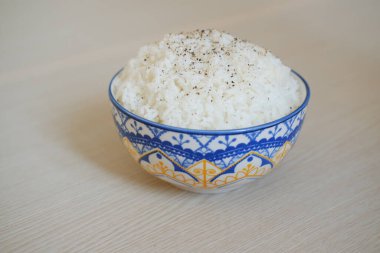 Tahta bir masada mavi bir kasede pirinç. Seçici odak.