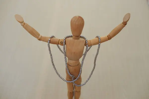 Wooden mannequin with necklaces and beads on a wooden background