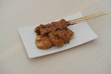 Tabakta tavuk budu ve masada çubuklar.