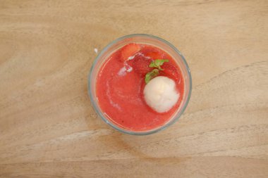 Tahta masadaki bardakta çilekli puding.