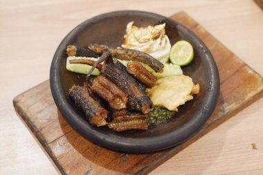 Cava mutfağı, ızgara yılan balığı ve tabakta salatalık turşusu.