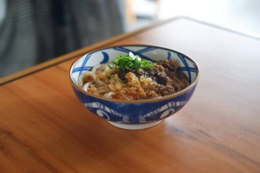 Japon usulü erişteli biftek ve sebzeli ahşap masa..