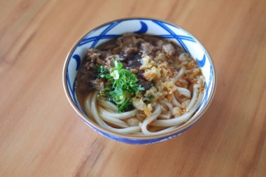 Tahta arka planda kasede sığır etli erişte..