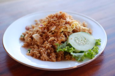 Tahta masada, beyaz tabakta kızarmış pirinç.